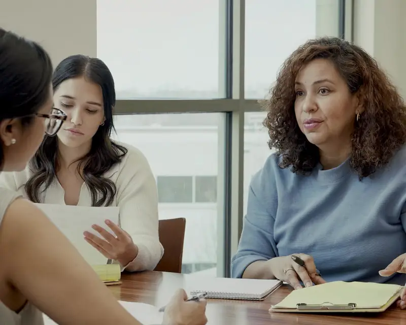 Agents and clients reviewing documents at a closing table